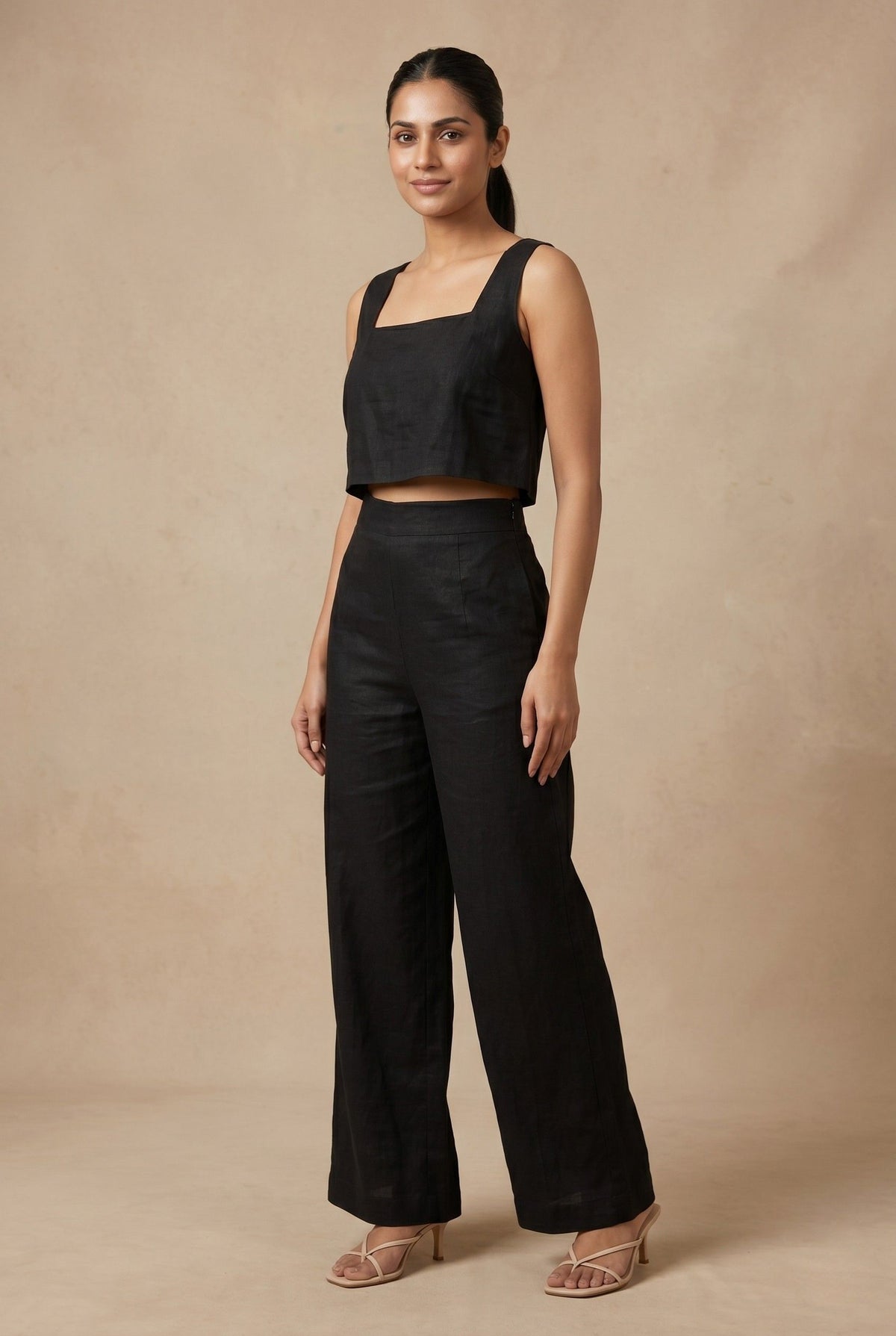 Angled view of the Noir linen co-ord set by Guilt & Class, highlighting the structured silhouette and fluid wide-leg trousers.