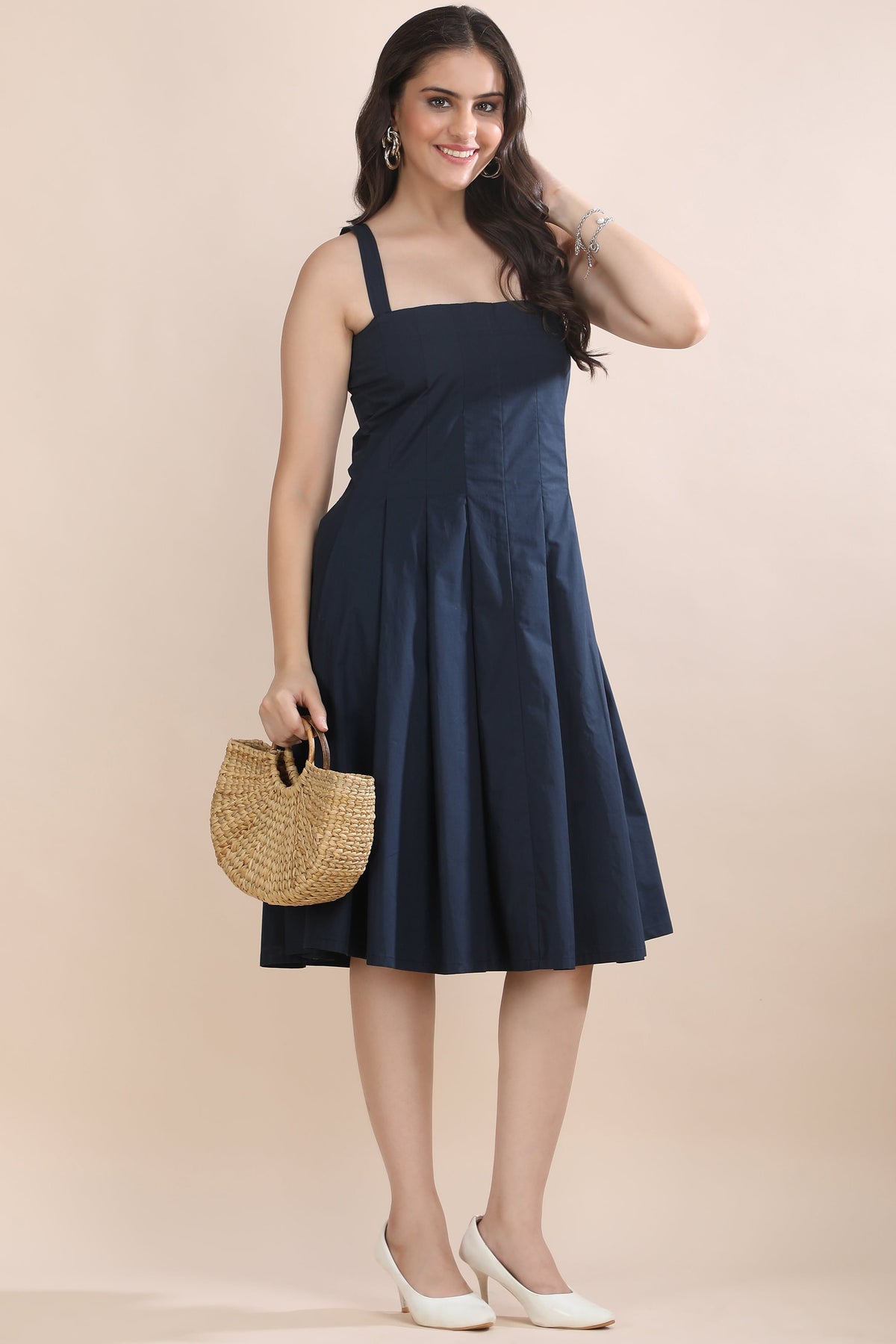 A model wearing the Shape in Blue cotton outfit set by Guilt & Class, featuring a structured fit & flare dress with a cropped overlay jacket.