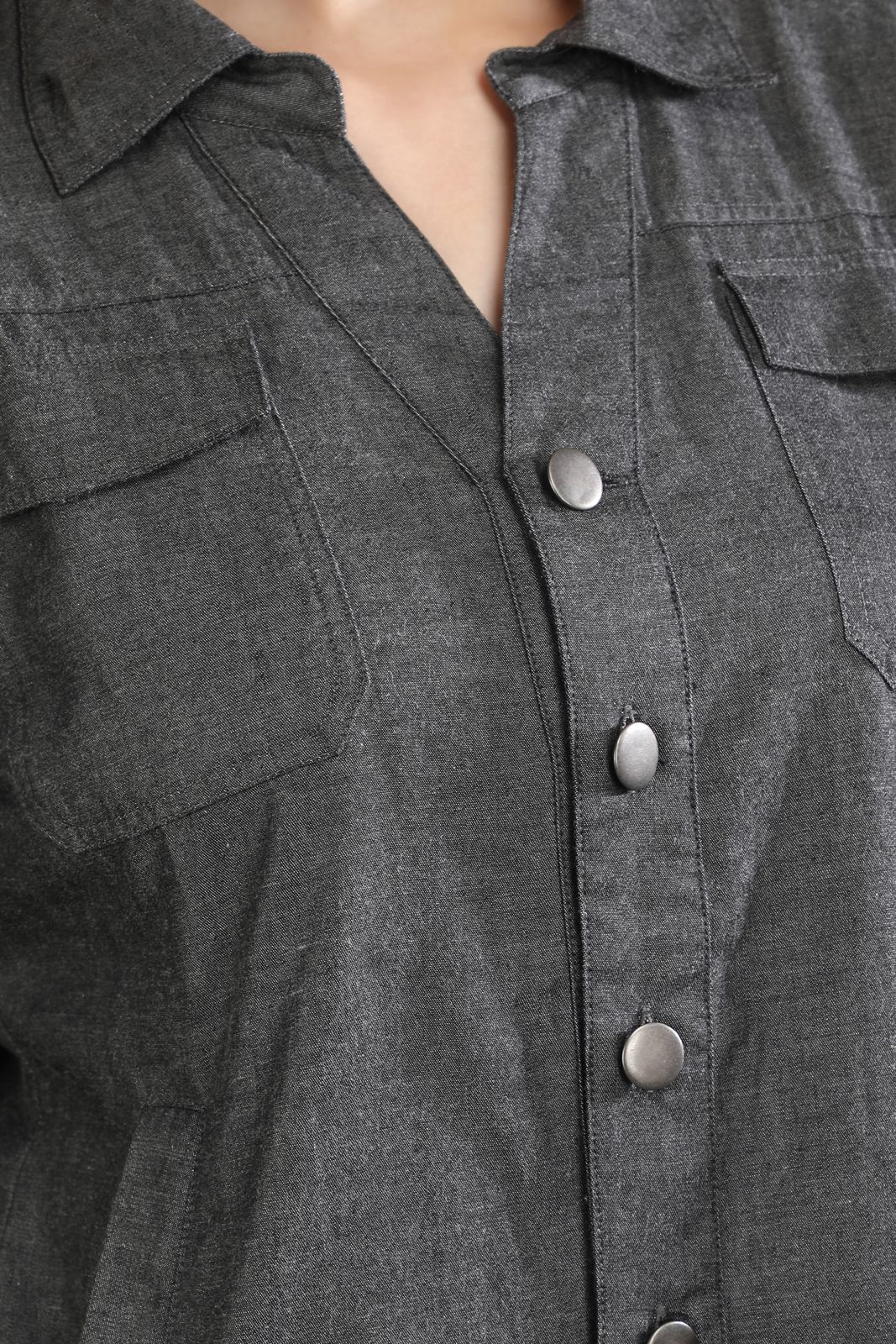 Close-up of the Ash in Form denim shirt by Guilt & Class, featuring utility flap pockets and metal button detailing.