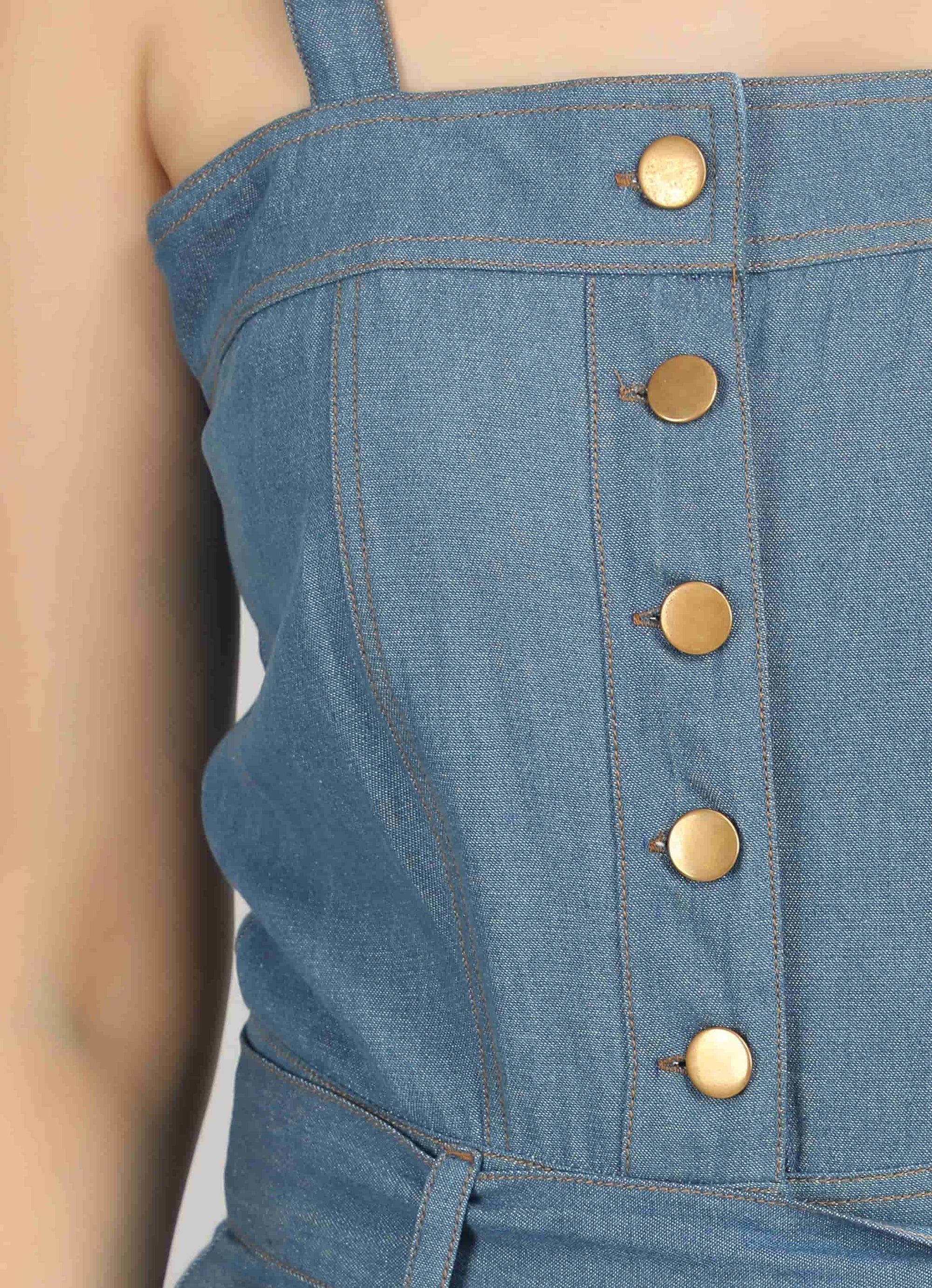 Close-up of the Caught in Denim jumpsuit by Guilt & Class, highlighting the panelled bodice and button detailing.