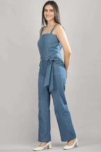 [blue] A model in motion wearing the Caught in Denim jumpsuit by Guilt & Class, showing the ease and movement of the wide-leg silhouette