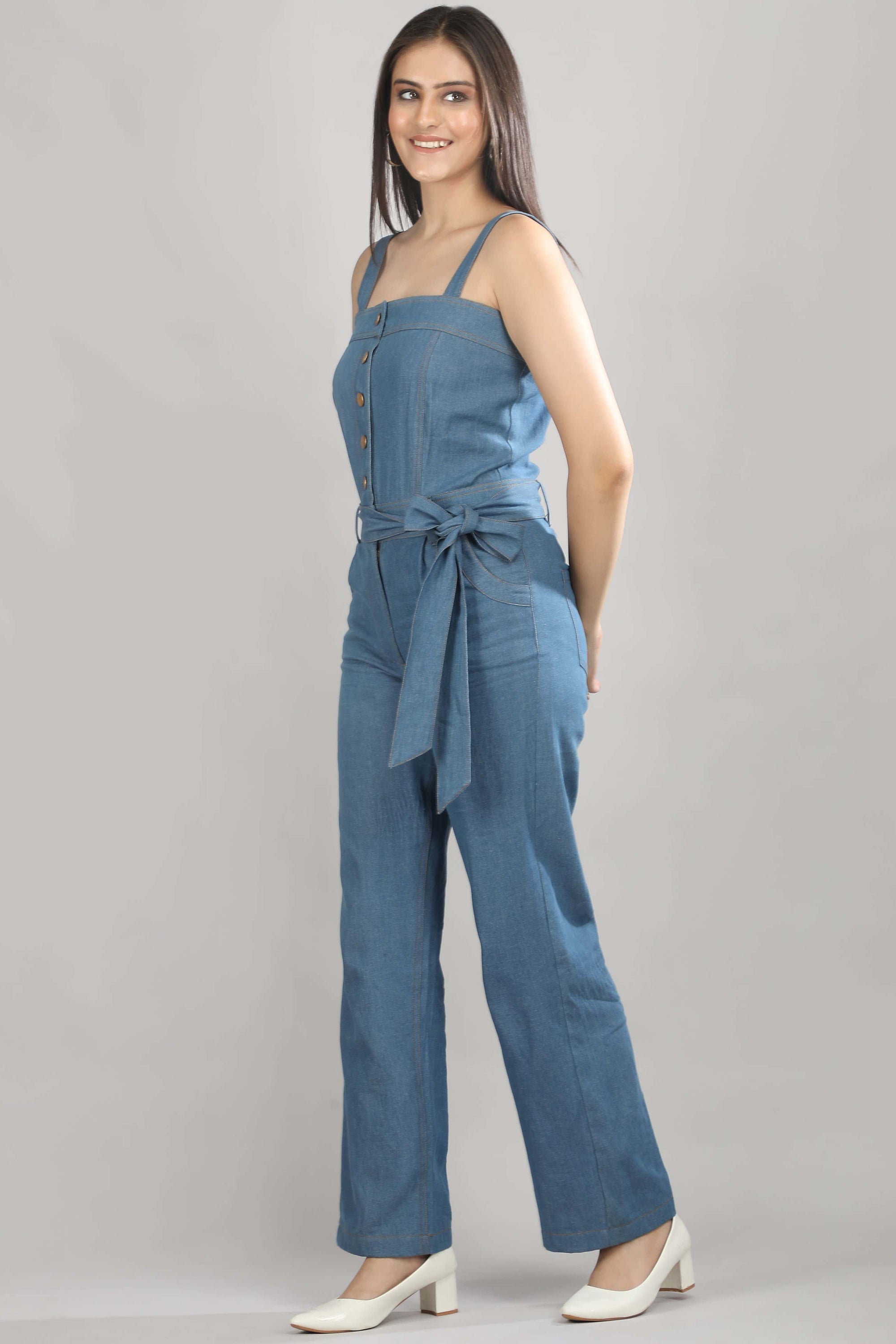 A model in motion wearing the Caught in Denim jumpsuit by Guilt & Class, showing the ease and movement of the wide-leg silhouette