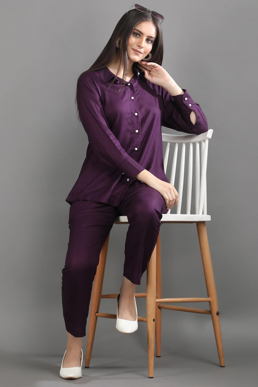 A model seated in the elegant mulberry co-ord set, showcasing the relaxed yet tailored fit of the premium matching top and trousers.