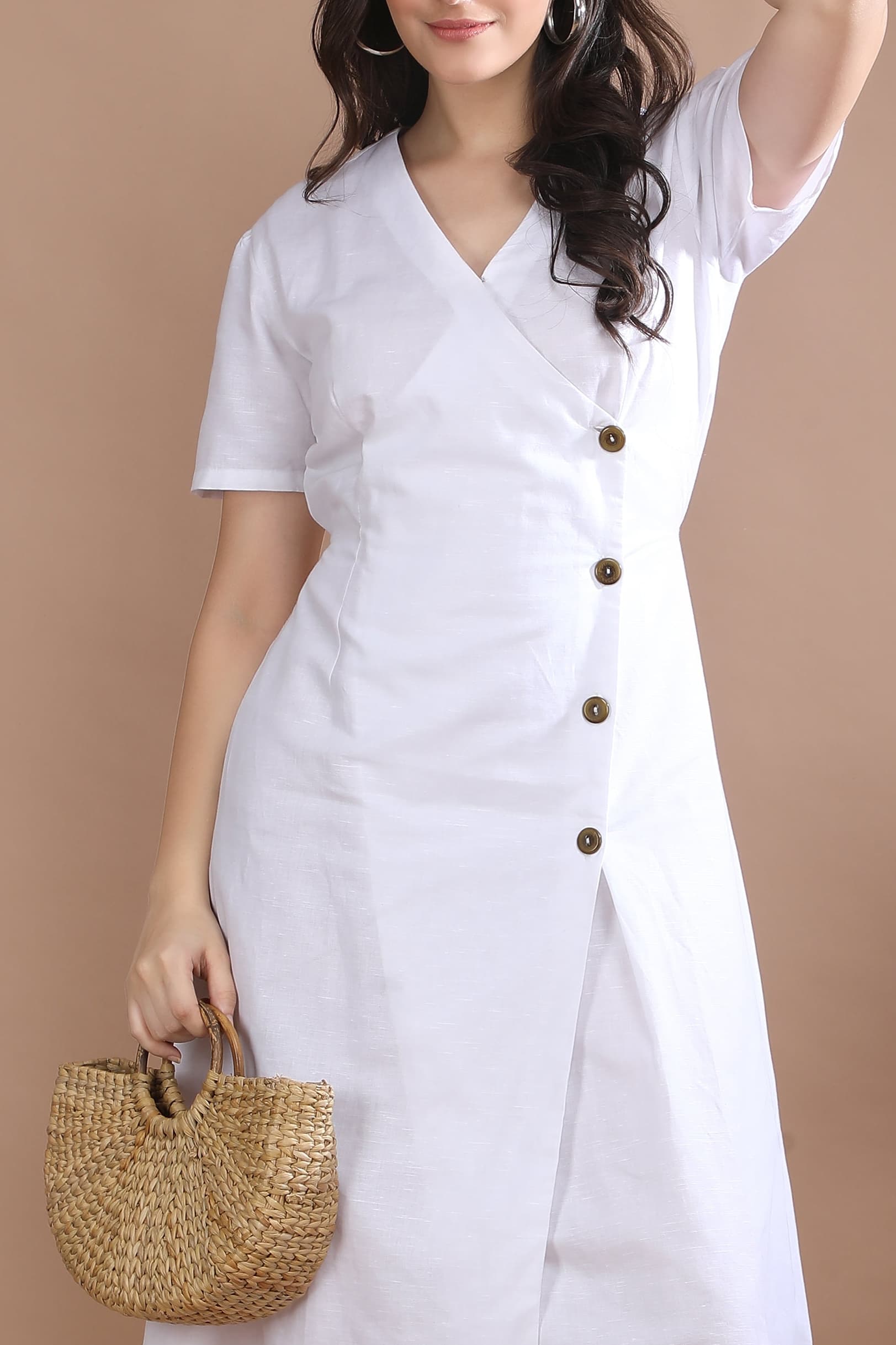 Close-up of the Ivory Wrap Midi Dress by Guilt & Class, featuring signature horn button detailing on a cotton-linen base.