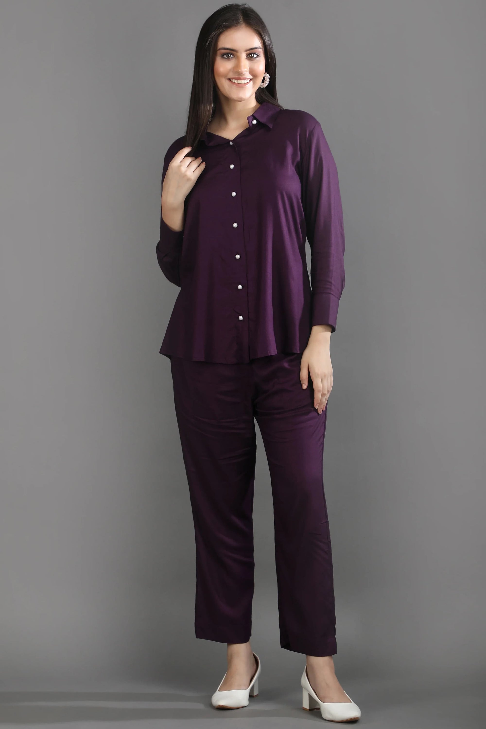 Front view of a woman wearing the premium mulberry purple long-sleeve co-ord set by Guilt & Class, styled with white heels.