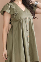 Close-up detail of the breathable cotton twill fabric, natural wooden buttons, and delicate flutter sleeve on the Olive Edit dress.