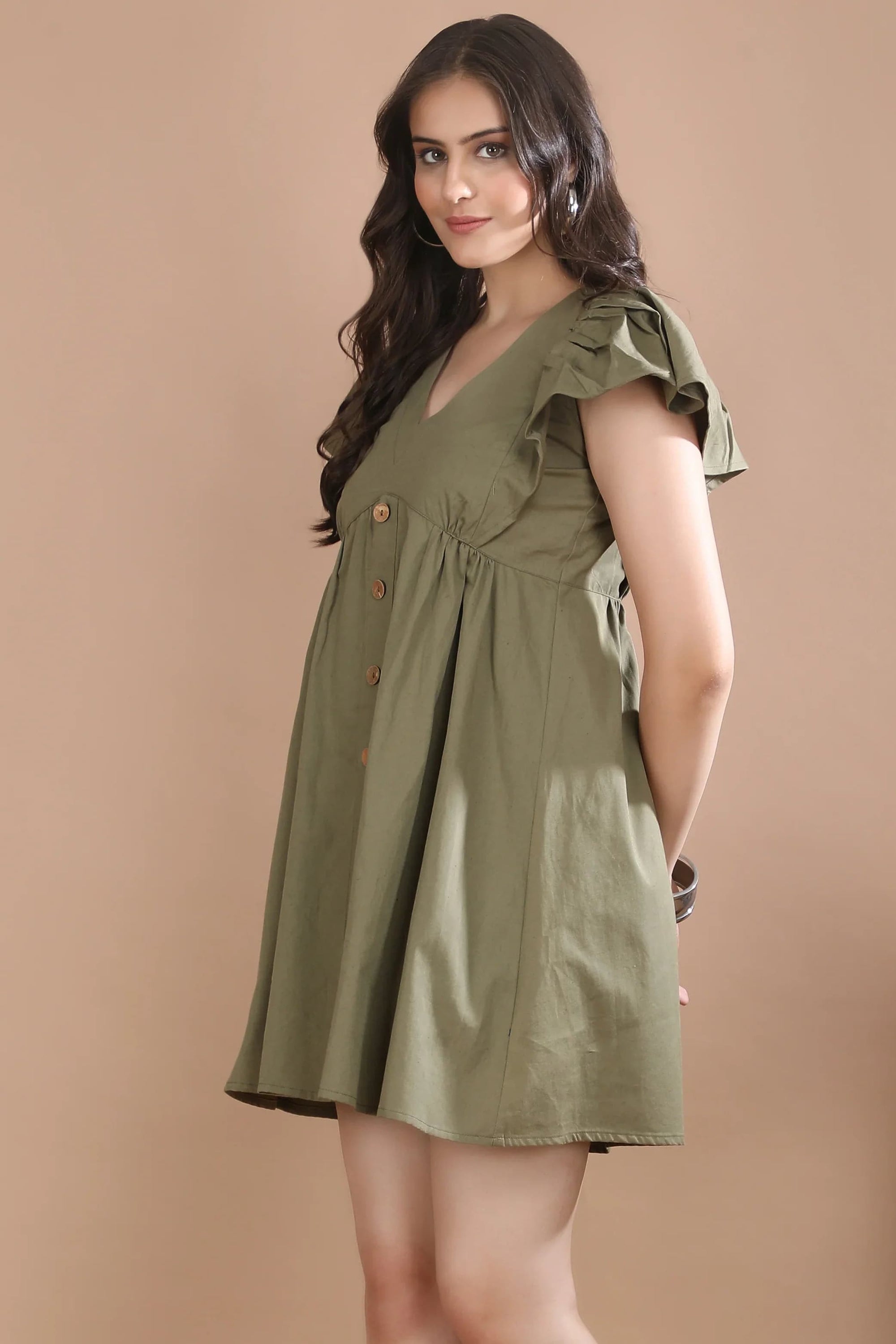 Side profile of the Olive Edit cotton twill dress highlighting the flattering A-line silhouette and structured flutter sleeves.