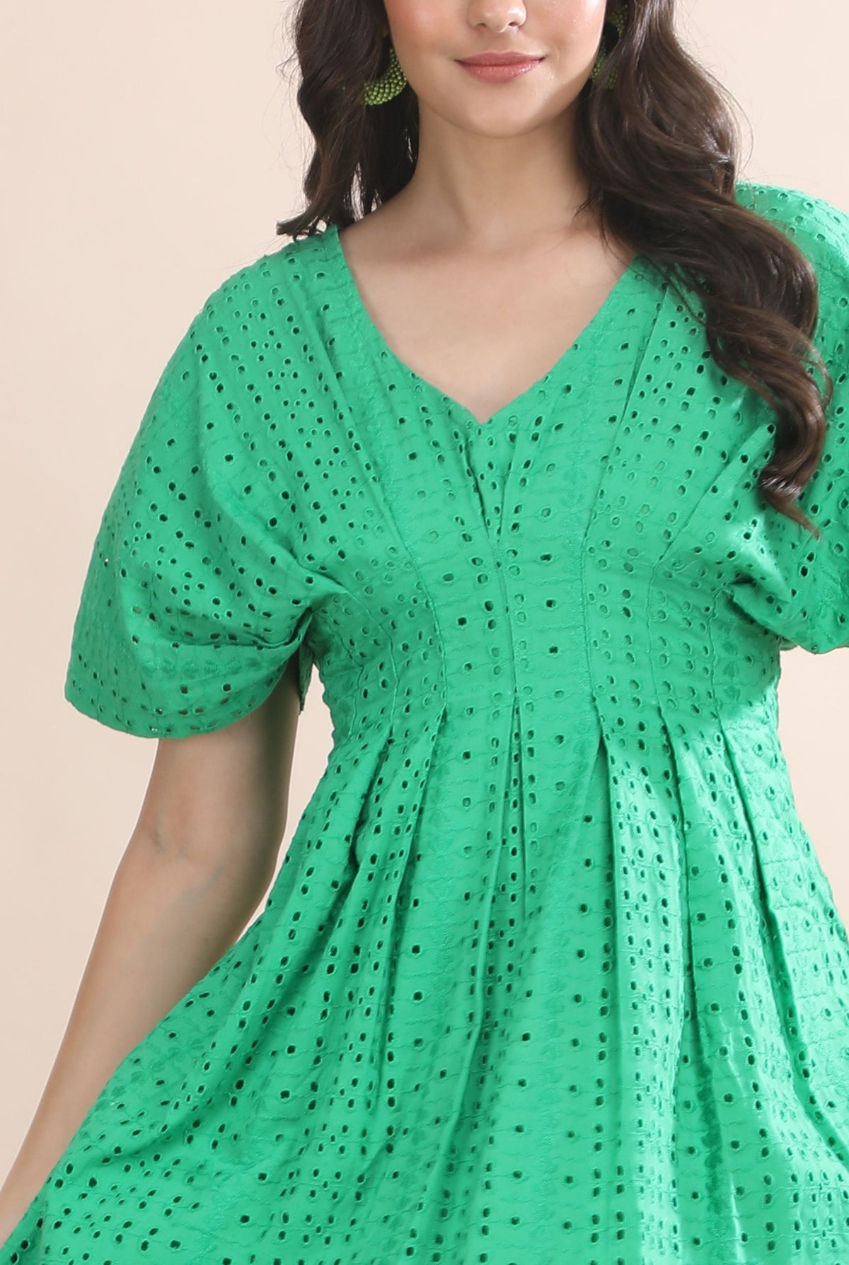 Close-up detail of the intricate green schiffli embroidery, pleated empire waist, and breathable premium fabric on the Guilt & Class dress
