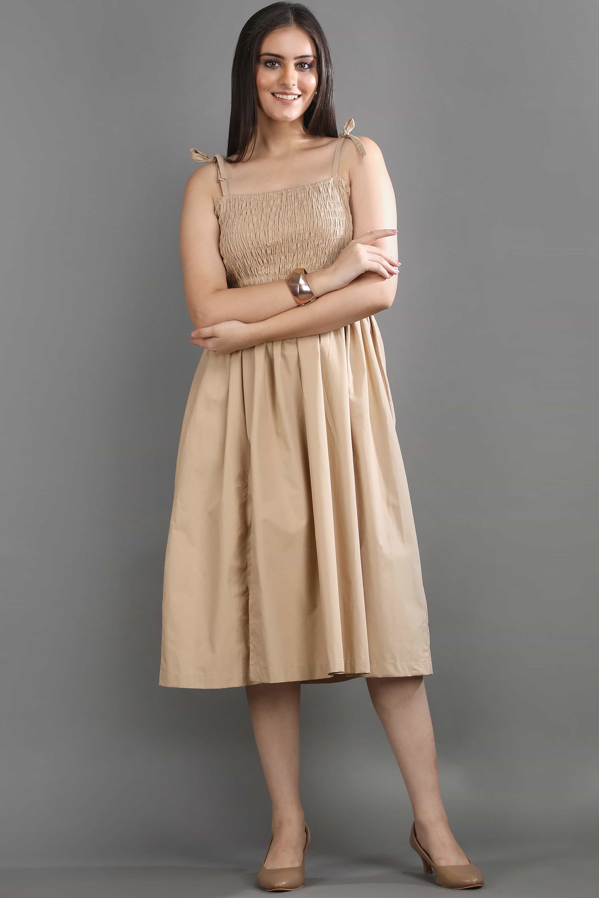 Angled view of the Second Skin midi dress by Guilt & Class, highlighting the flattering smocked fit and flowing silhouette.