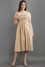 A model wearing the Second Skin midi dress by Guilt & Class, featuring a smocked bodice, adjustable straps, and a soft structured cotton finish.